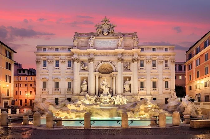 Der Trevi-Brunnen in der Dämmerung unter einem rosa Himmel
